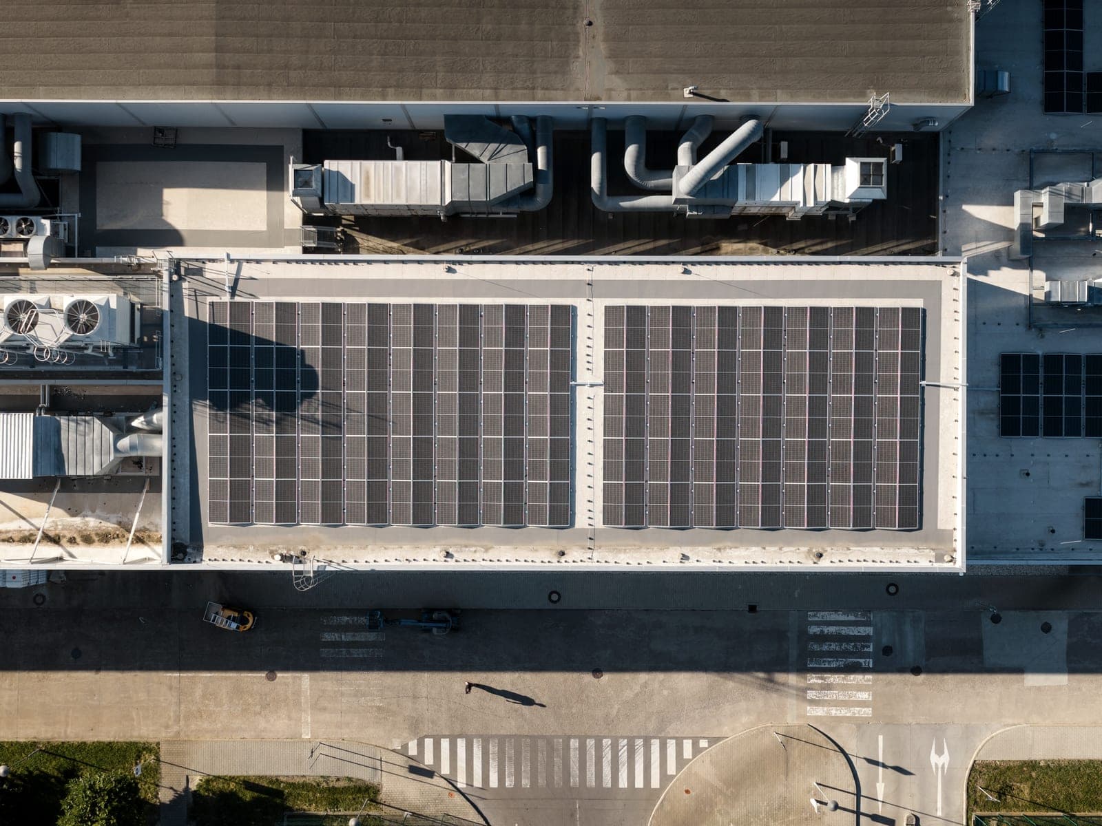 Senkrechter Drohnenblick auf ein Hallendach mit Photovoltaikfeld