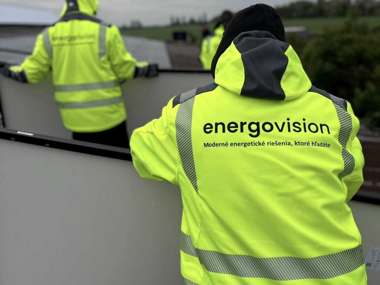 Montageteam von Energovision in Warnjacken bei der Modulmontage auf dem Dach