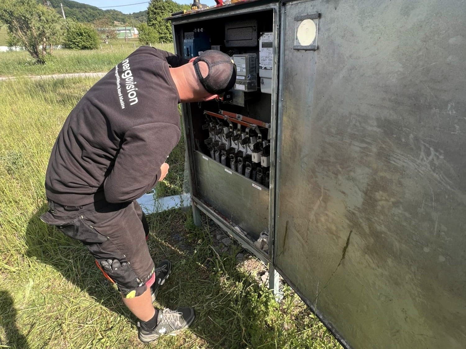 Elektriker von Energovision arbeitet am NS-Verteiler einer Masttrafostation