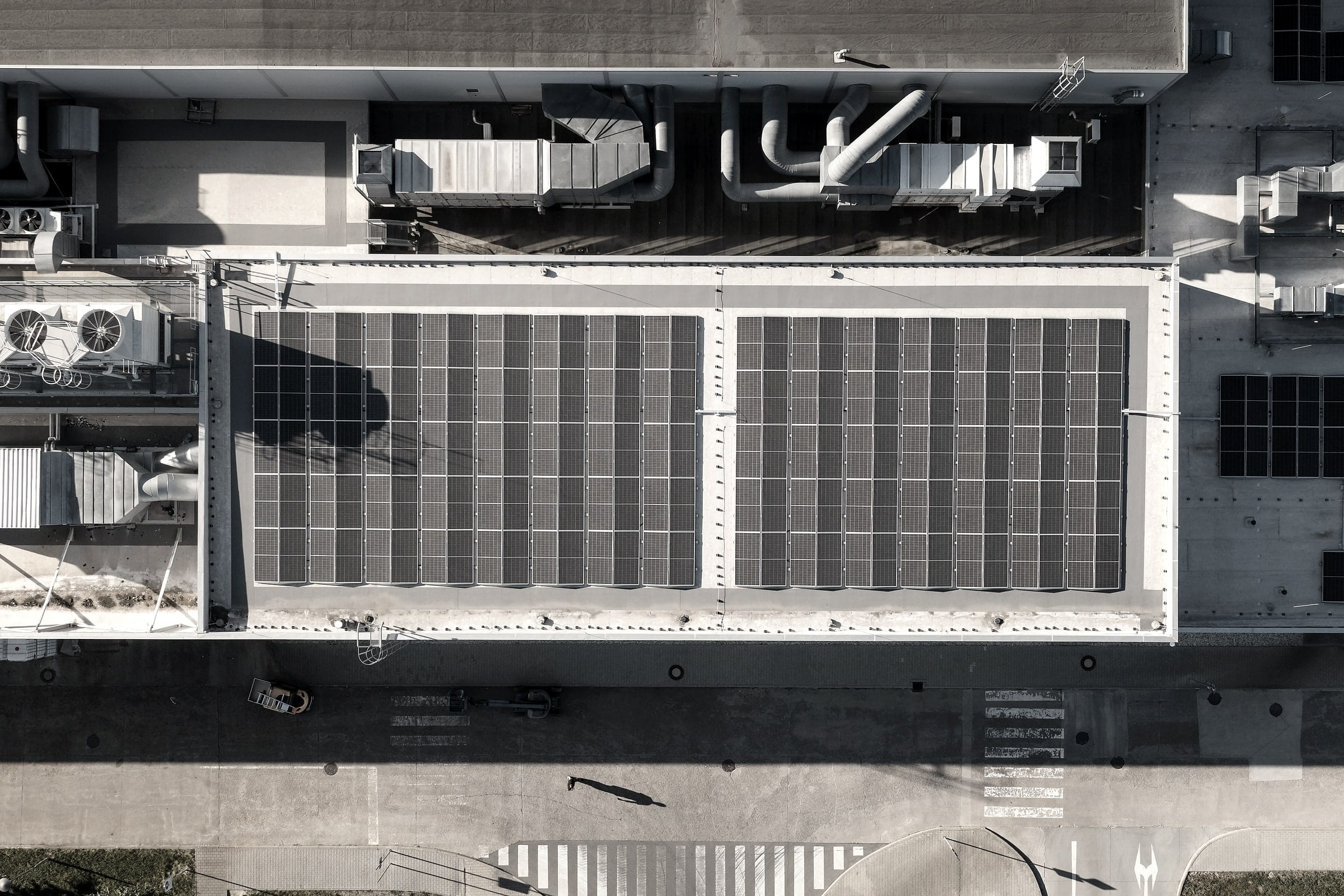 Senkrechte Luftaufnahme eines Hallendachs mit zwei PV-Modulfeldern