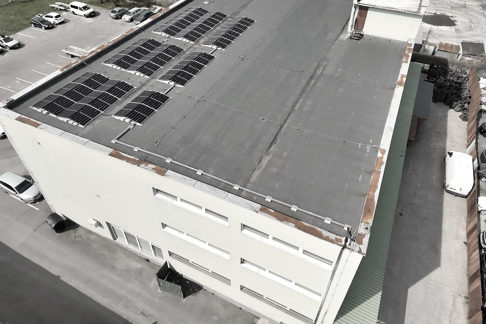 Orthofoto eines Gebäudes mit Photovoltaik auf dem Dach und Parkplatz